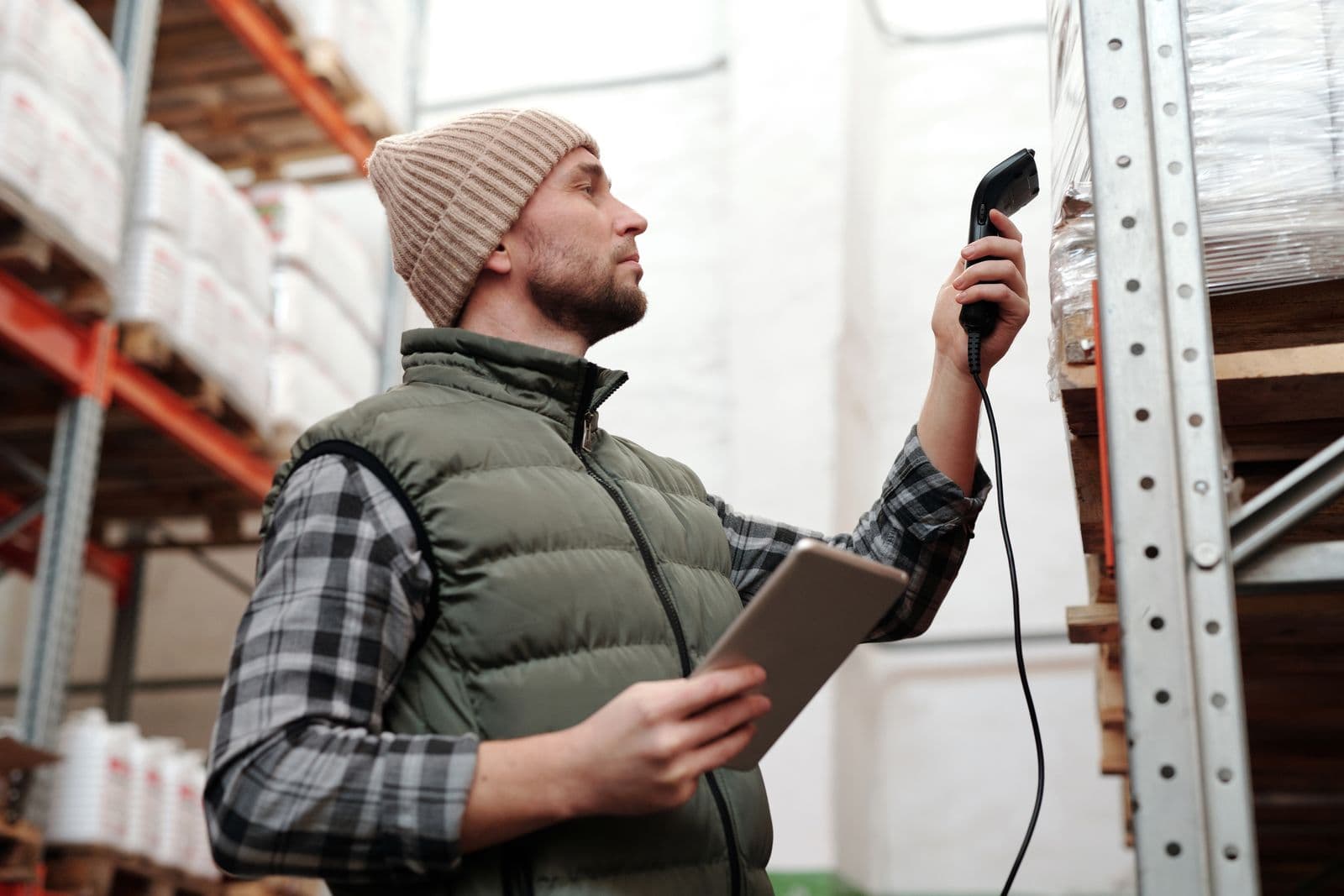 A warehouse worker scanning a package with a handheld scanner and tablet