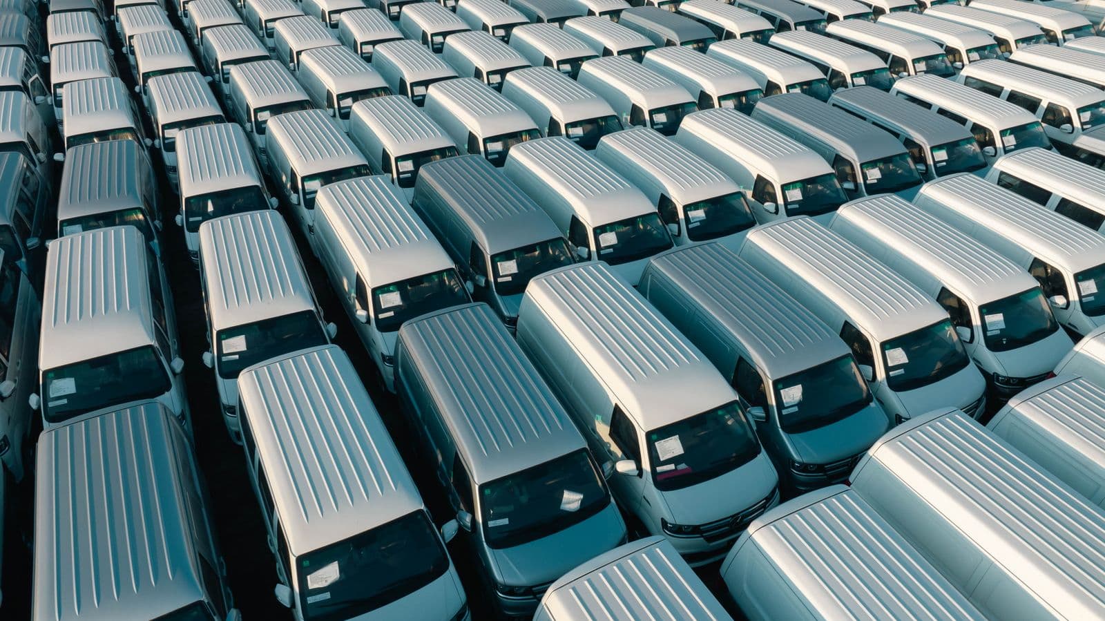 Aerial view of a fleet of delivery vans parked in orderly rows